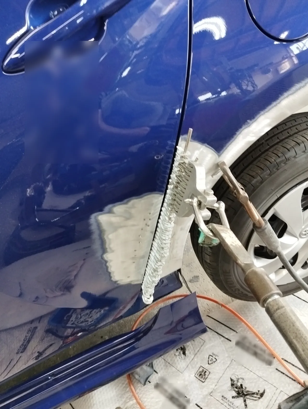 ヤリスの左リヤクォーターの縁に溶接した波形のワイヤーと、くし形の工具の寄り(引き出し板金)