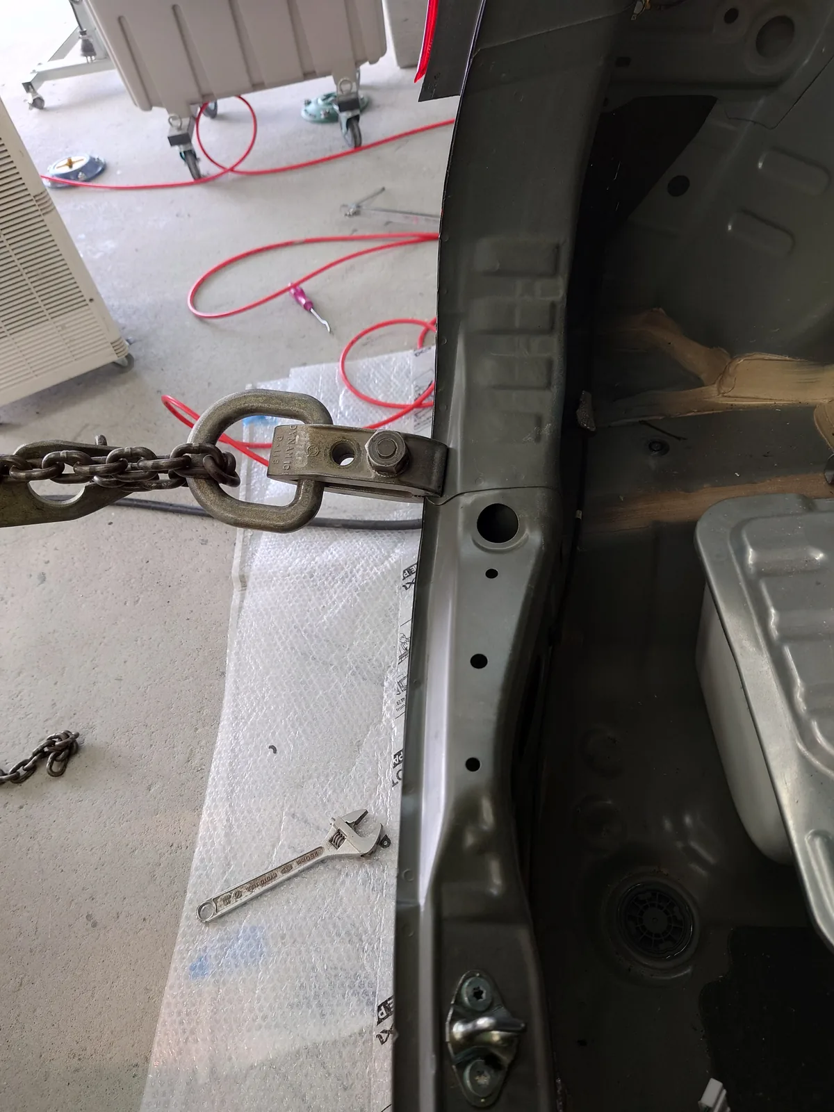 ホンダ フィットのリヤの車体に、引くためのチェーンを掛けた状態