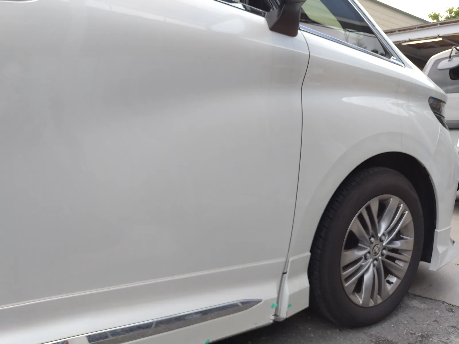 40系アルファードの右側。フロントタイヤの後ろ、サイドエアロの前の端の損傷