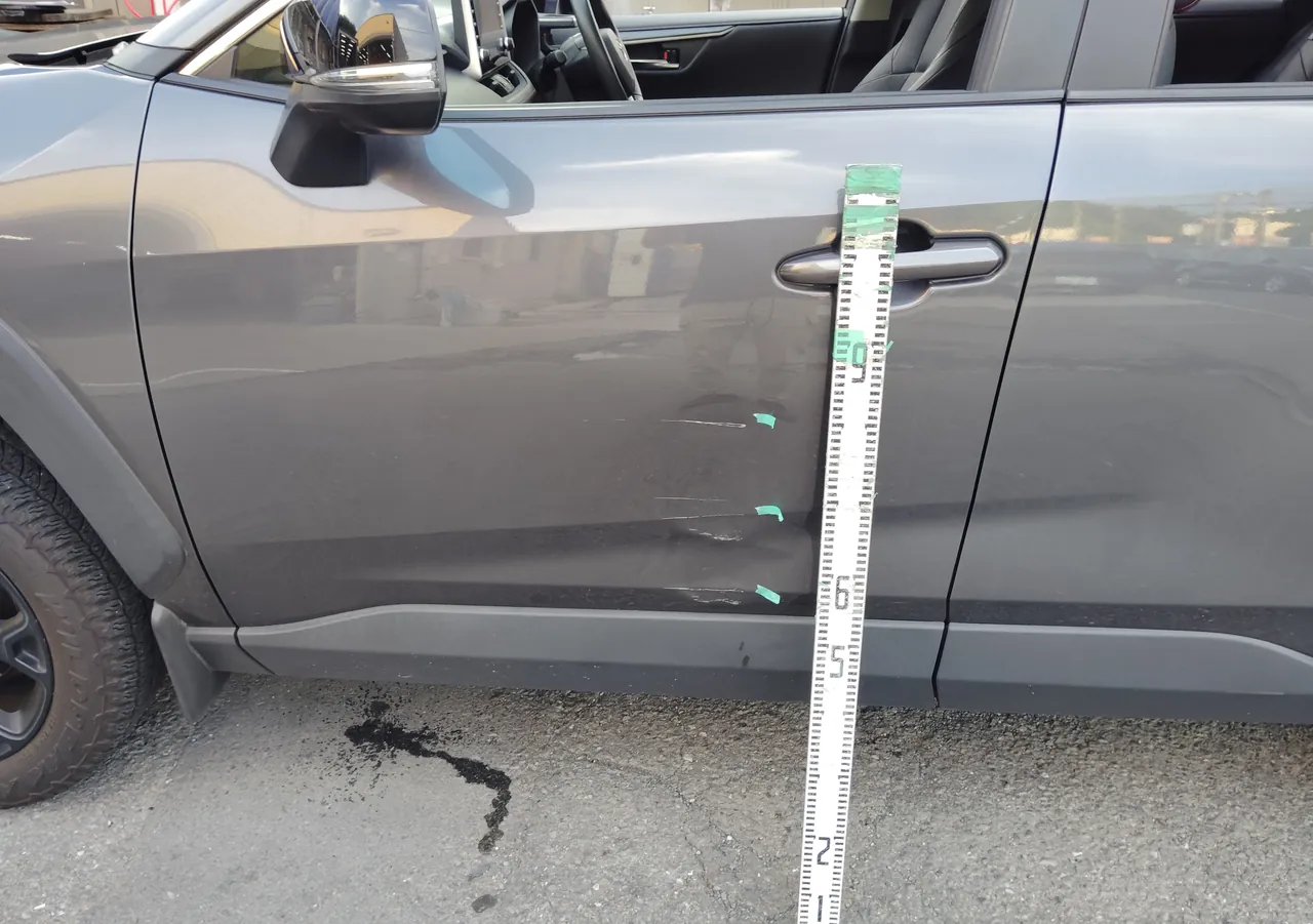 トヨタ RAV4 左フロントドアに目盛りの棒を当てて、損傷の高さを記録