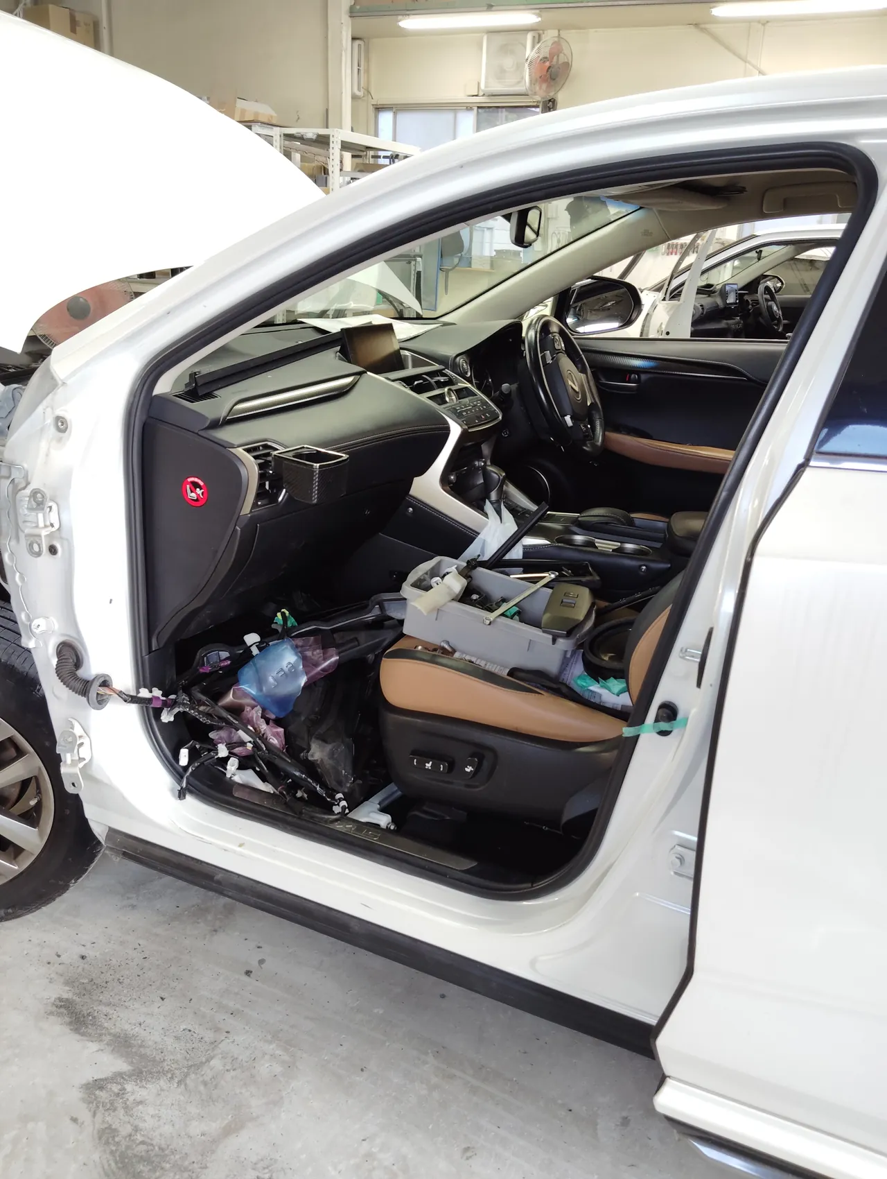 左フロントドアを外したレクサスNX。開口部から配線が出ていて、車内の茶色のシートが見える