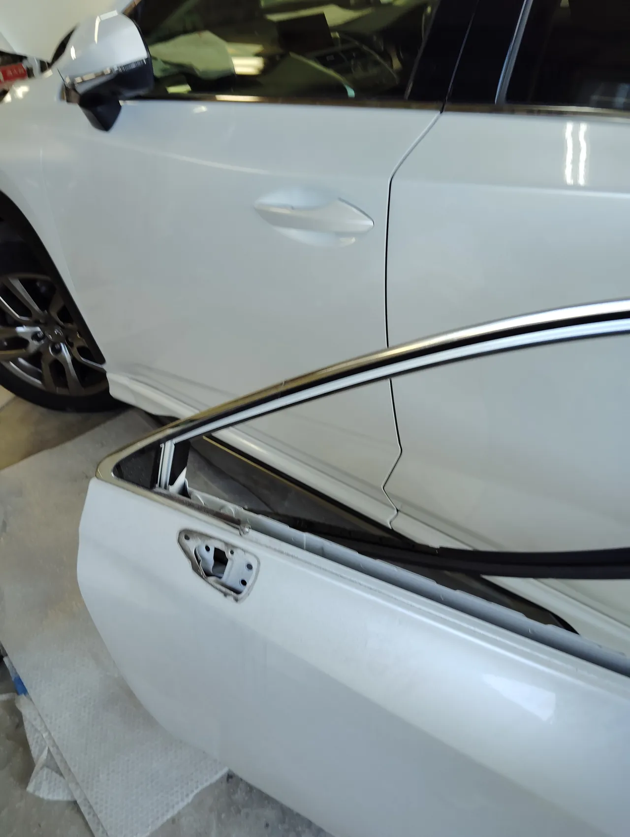 レクサスNXから外した元の左フロントドア（手前）と、新しいドアを付けた車（奥）