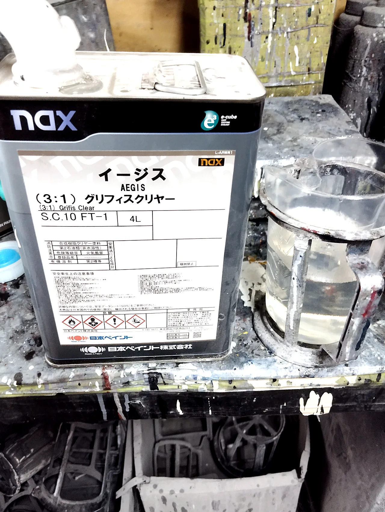 30系アルファードの塗装に使った日本ペイント nax イージス（3:1）グリフィスクリヤーの缶と計量カップ