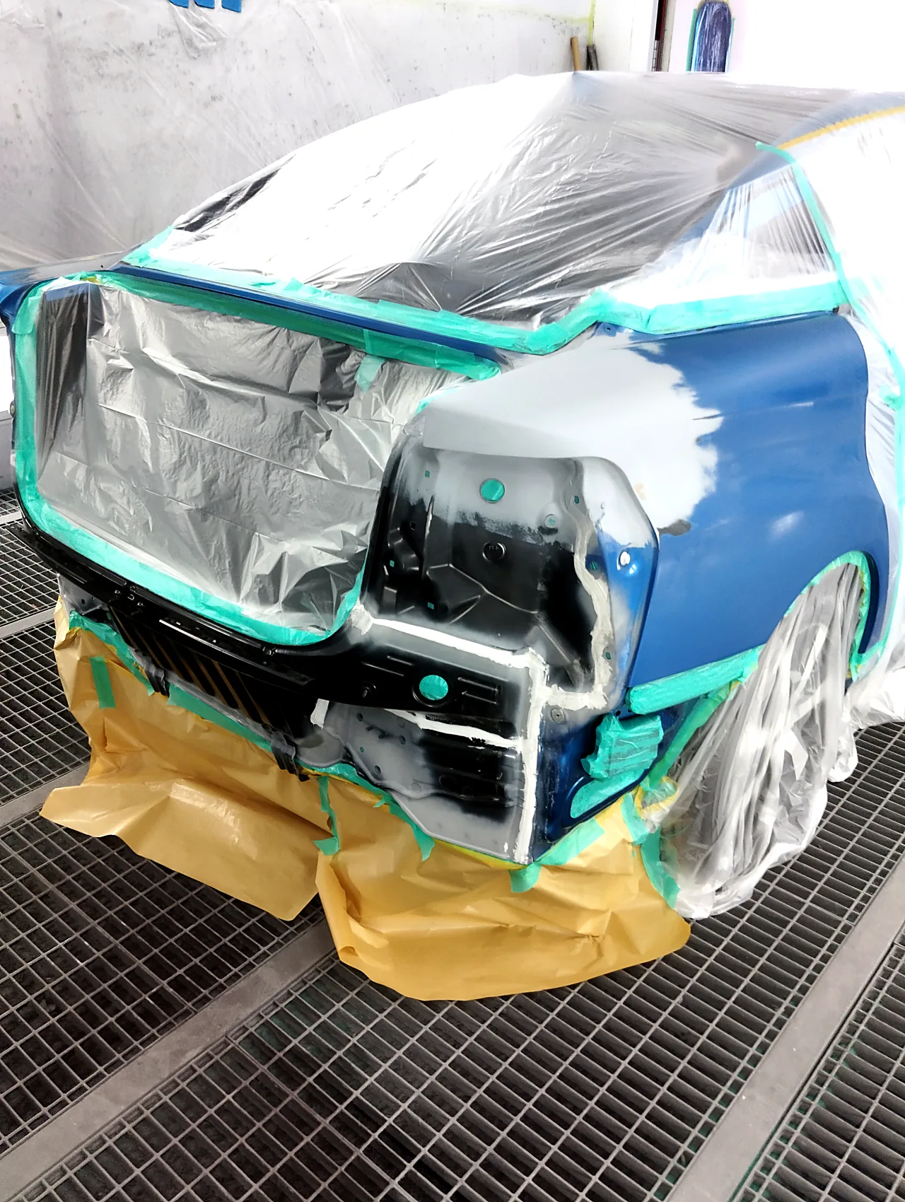 塗装ブースのMIRAIの右後ろの角。パテを付けた上面にグレーのサフェーサー、荷室はビニールでふさぐ