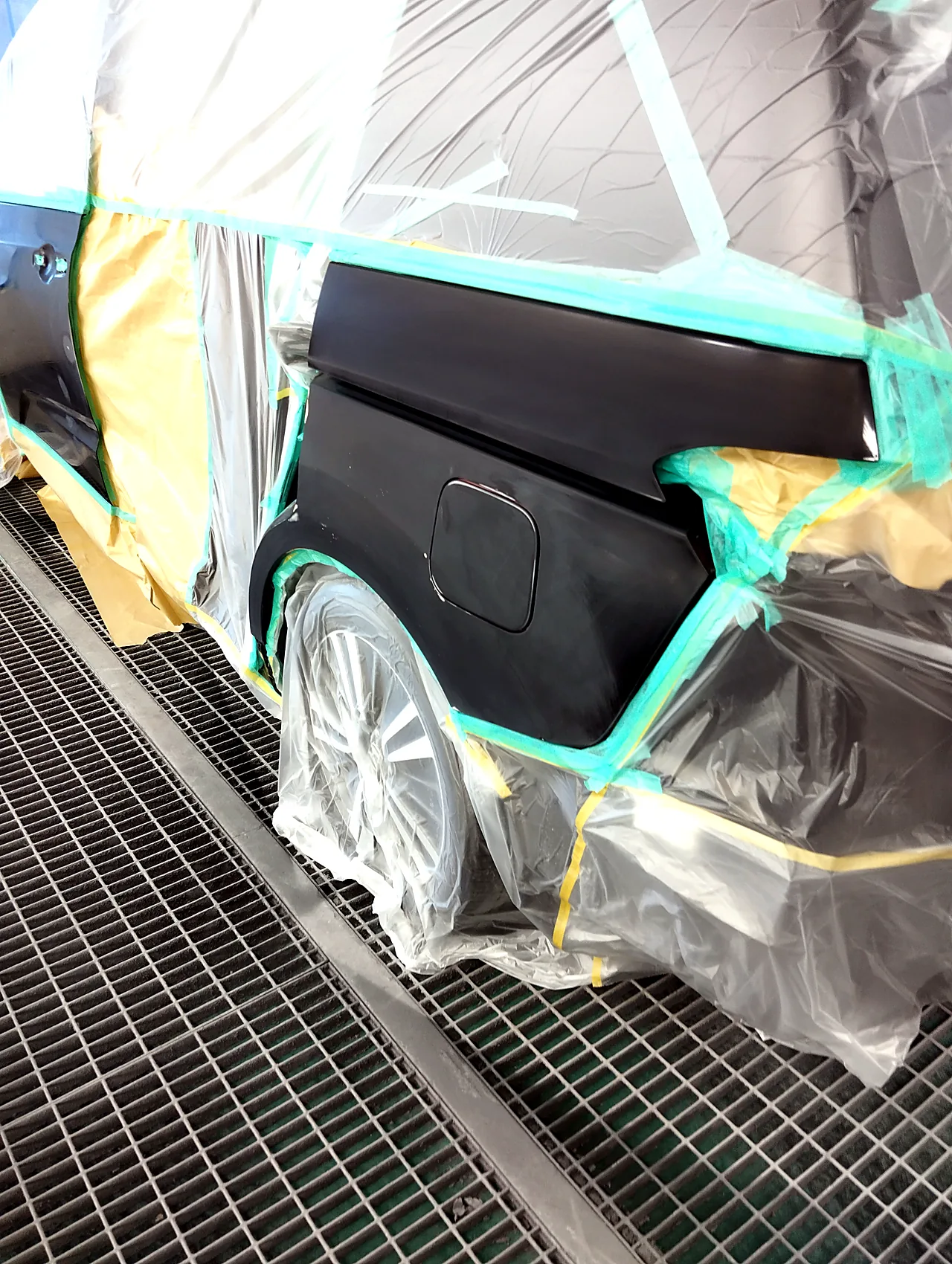 車全体をビニールで包んだ塗装ブースのオデッセイ。給油口のふたまで研いだ左リヤクオーター(塗る前)