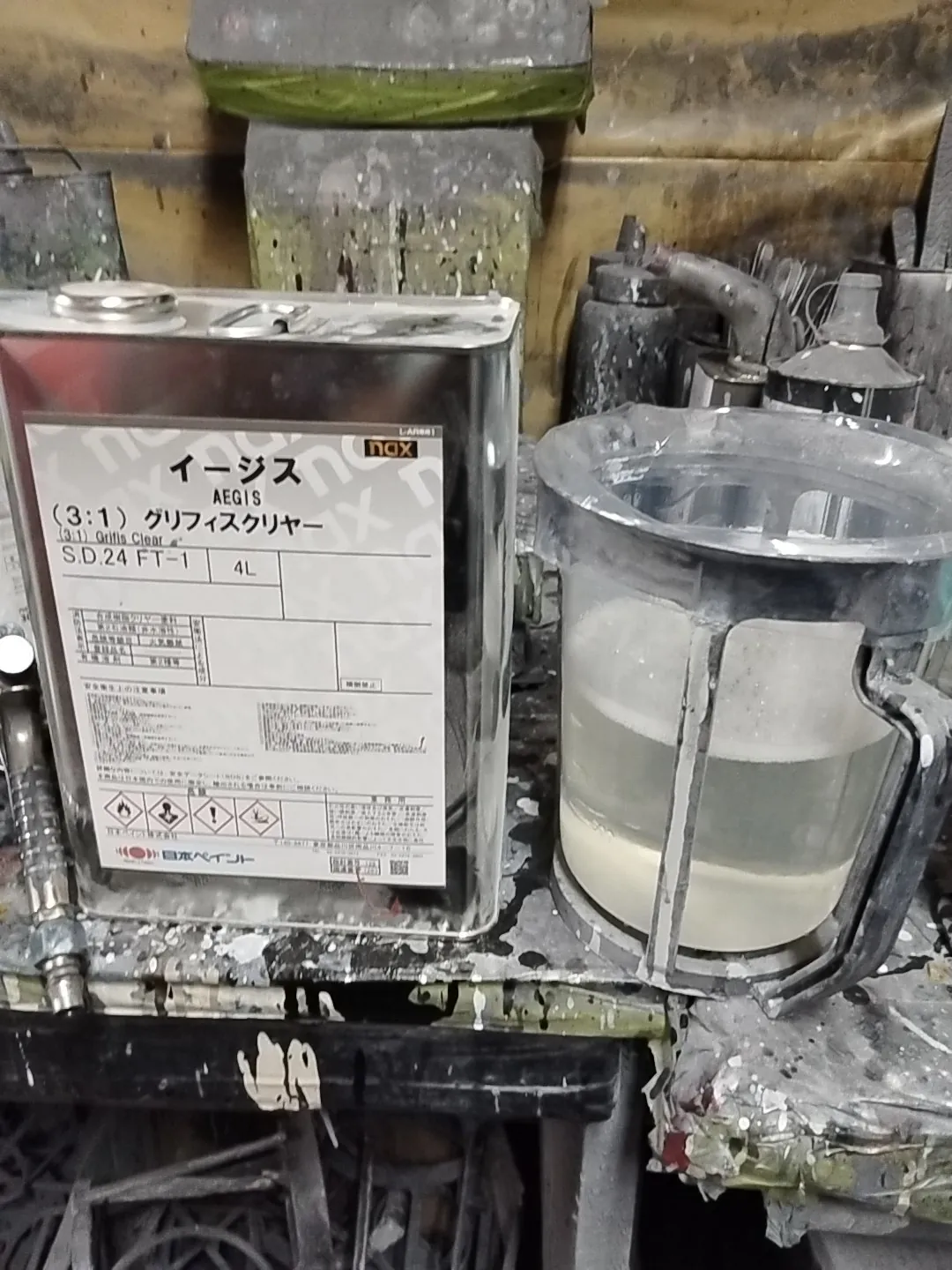 クリヤーの缶(日本ペイント nax イージス(3:1)グリフィスクリヤー)と調合カップ。オデッセイの塗装で使用