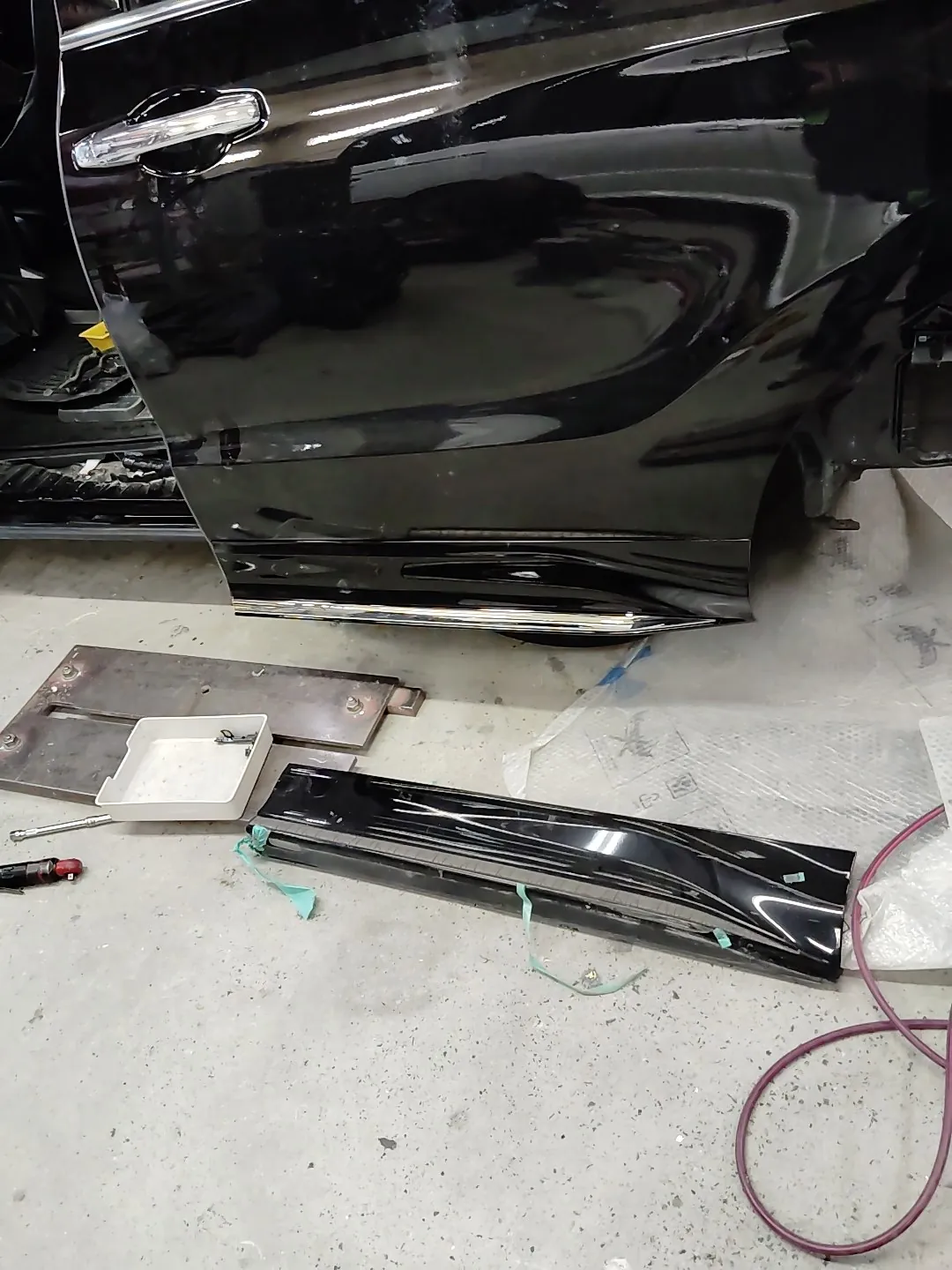新品の左スライドドアが付いたオデッセイと、床に置いた緑のテープ付きの外した元のモール
