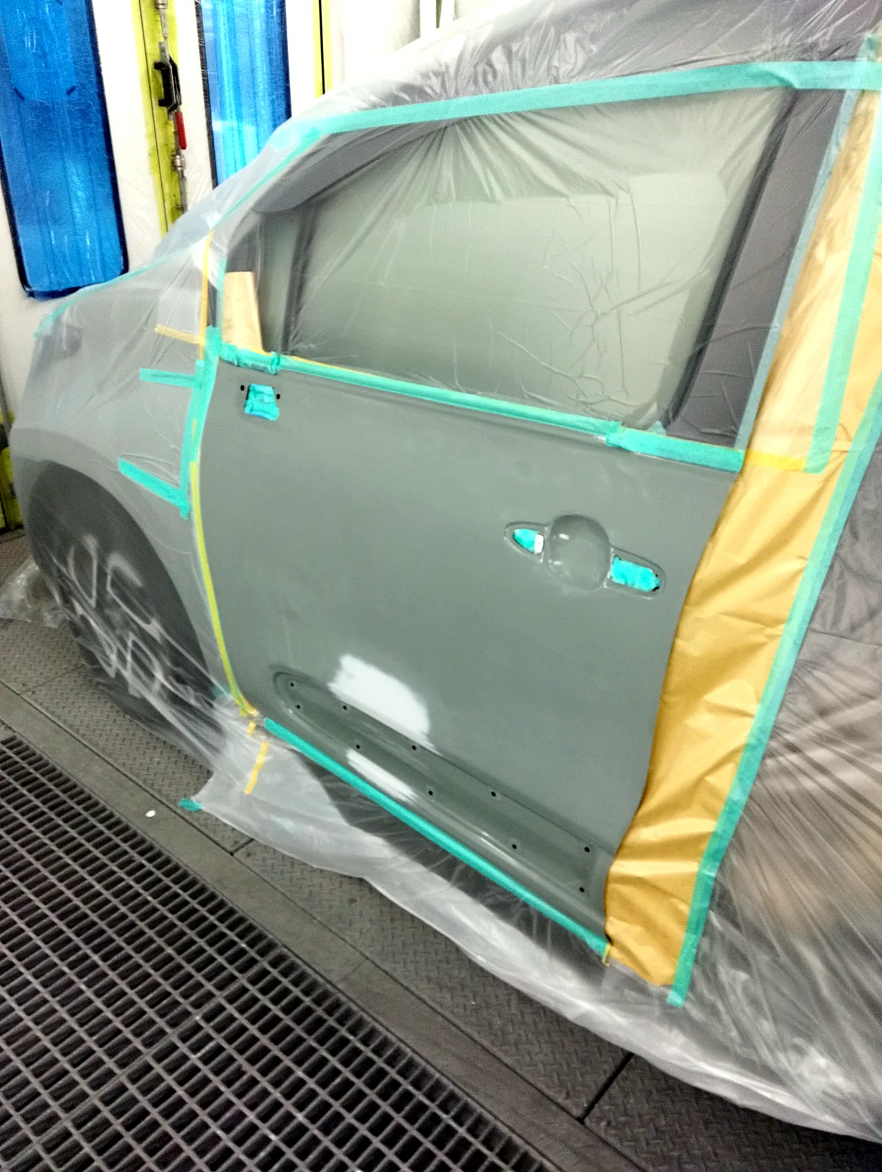 塗装ブースで左フロントドアを1枚まるごと出したシエンタ。ハンドルの穴はテープ、スライドドアの開口部は紙で覆う(塗る前)