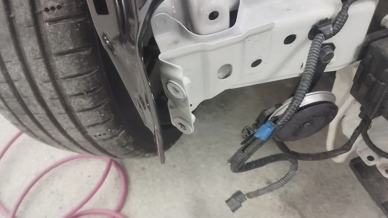 GR86に取り付けた黒い新品の右フロントフェンダーの前の下の端と、車体側の白いブラケット