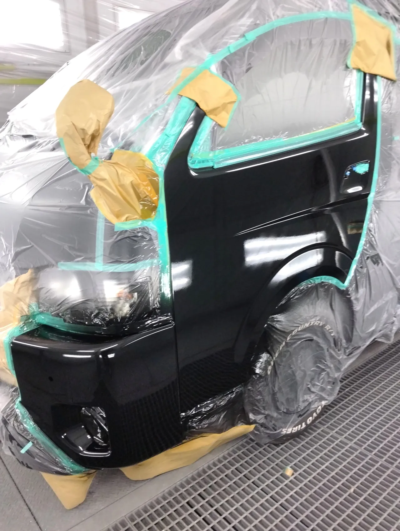 カラー番号209で塗装し、クリヤーまで終えたハイエースの左フロントドアとバンパー左角（塗装ブース）