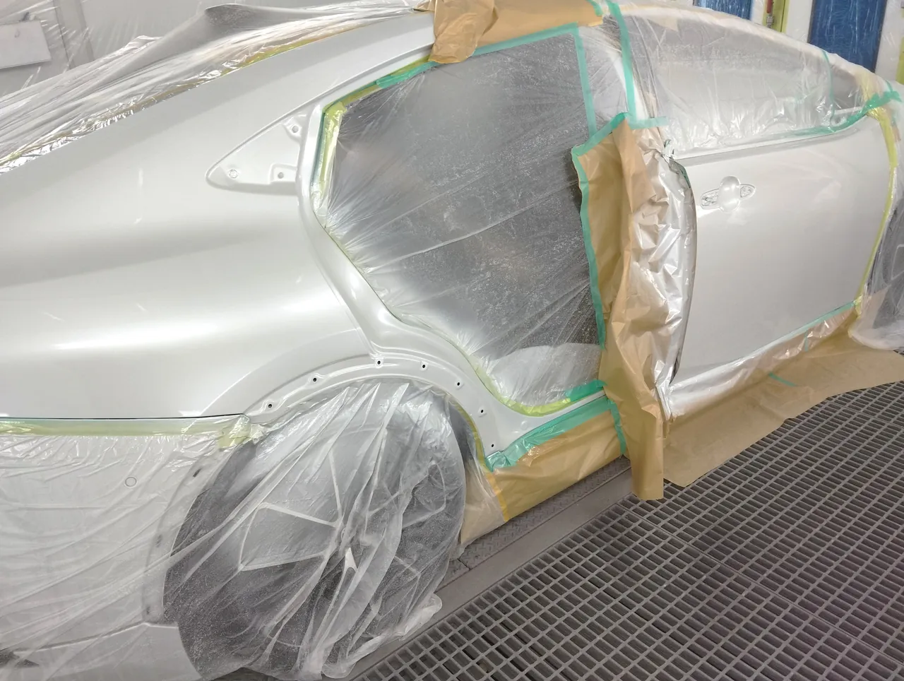 塗装ブースで089の白に塗り終えたプリウスの右側面(右リヤクォーターから右フロントドアまで)