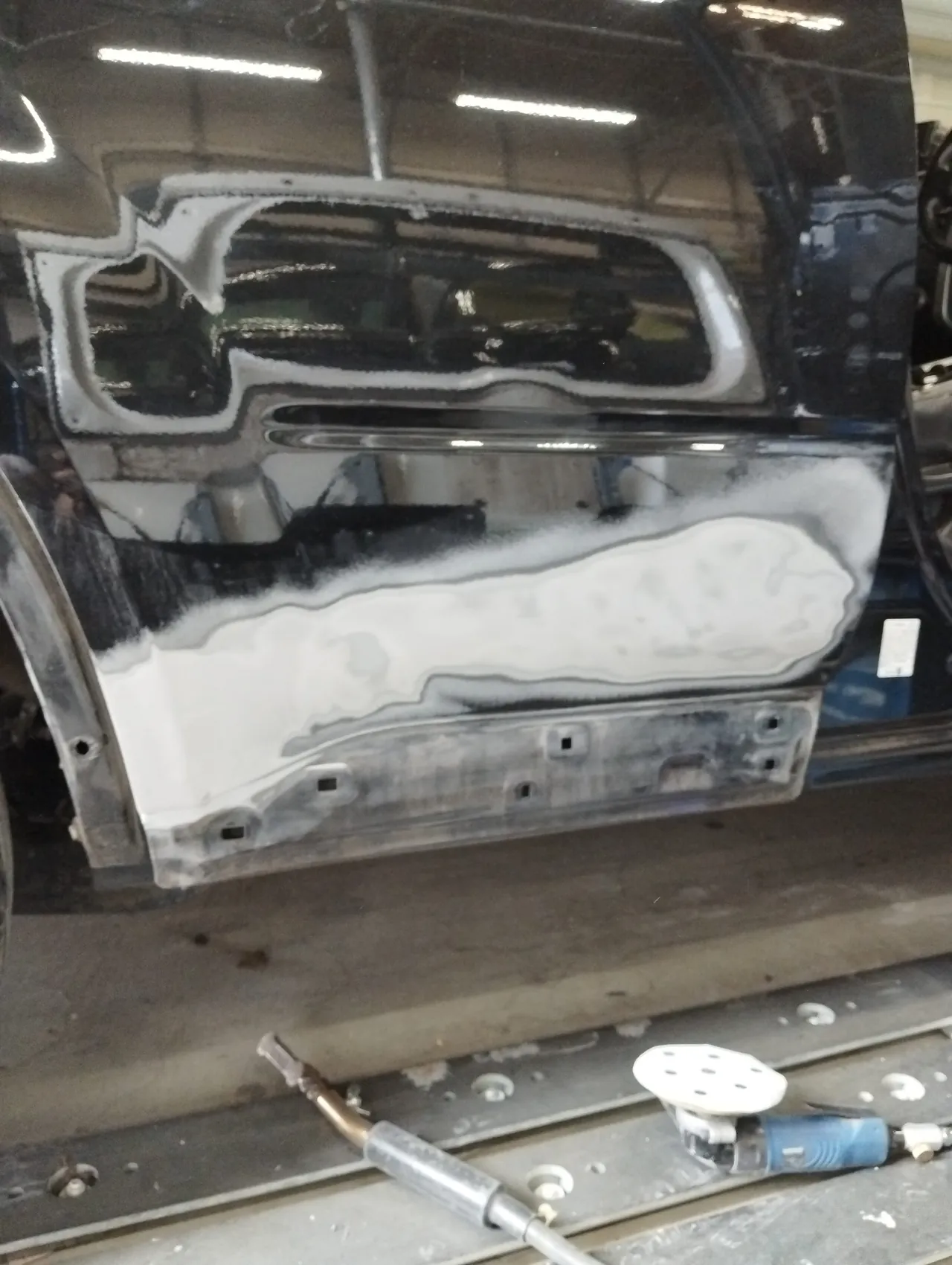 日産 T31エクストレイルの右リヤドアの下半分を段をつけて研いだ跡。内側の明るい面は鉄板