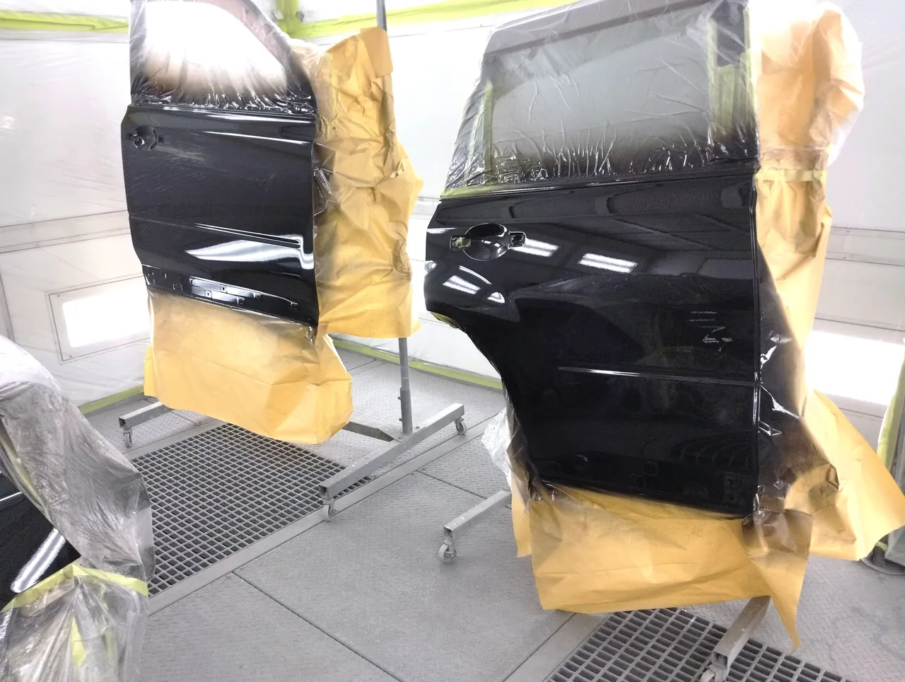 塗装ブースのスタンドで塗り終えた日産 T31エクストレイルの前後のドア(G41の黒)