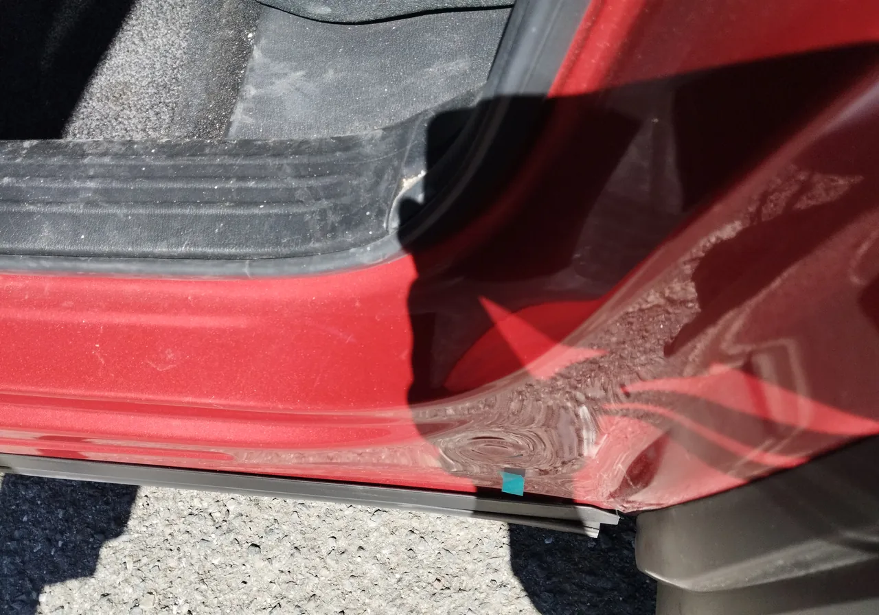 マツダ CX-5のサイドシルの後ろの端の寄り（修理前）。鉄板が曲がり、塗装の表面にしわのような模様
