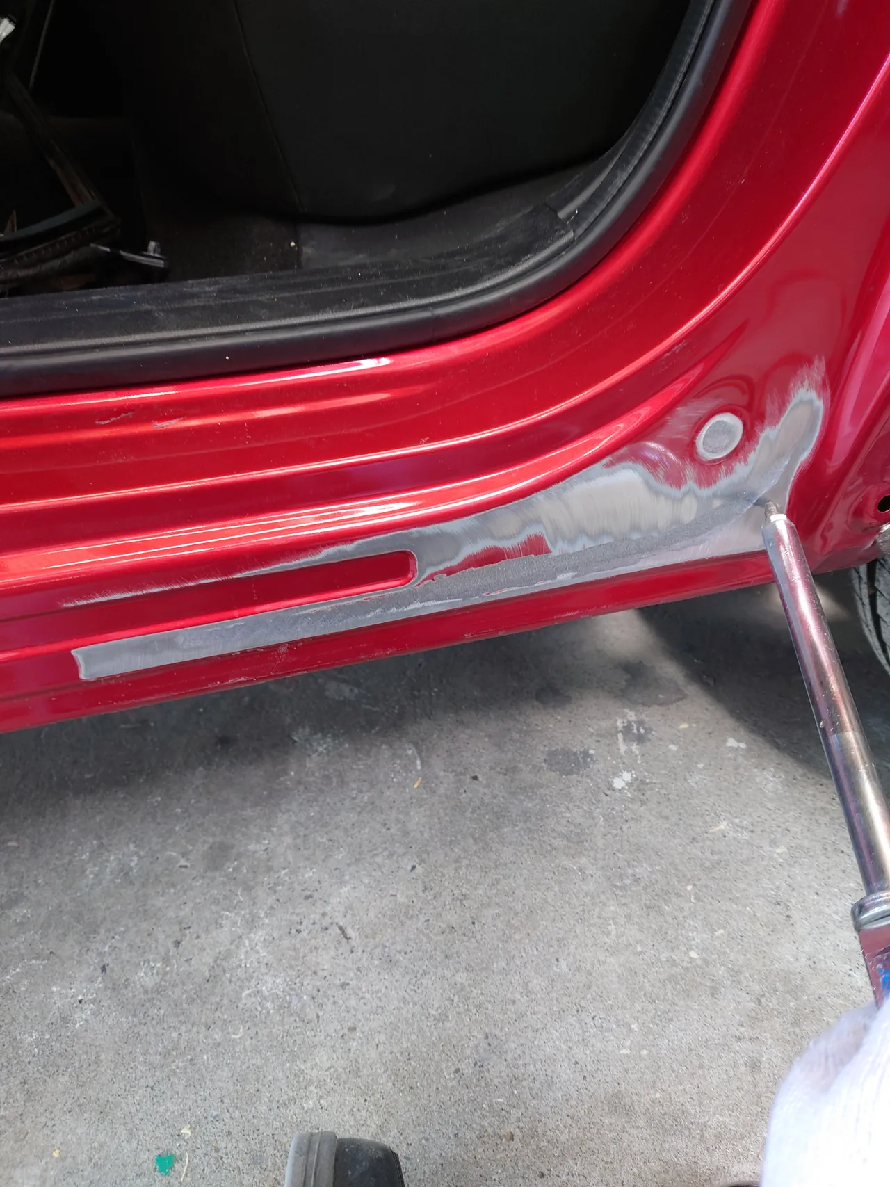 引き出し板金中のマツダ CX-5のサイドシルの後ろの端。研いだ跡（鉄板が出ている）が段になって広がる