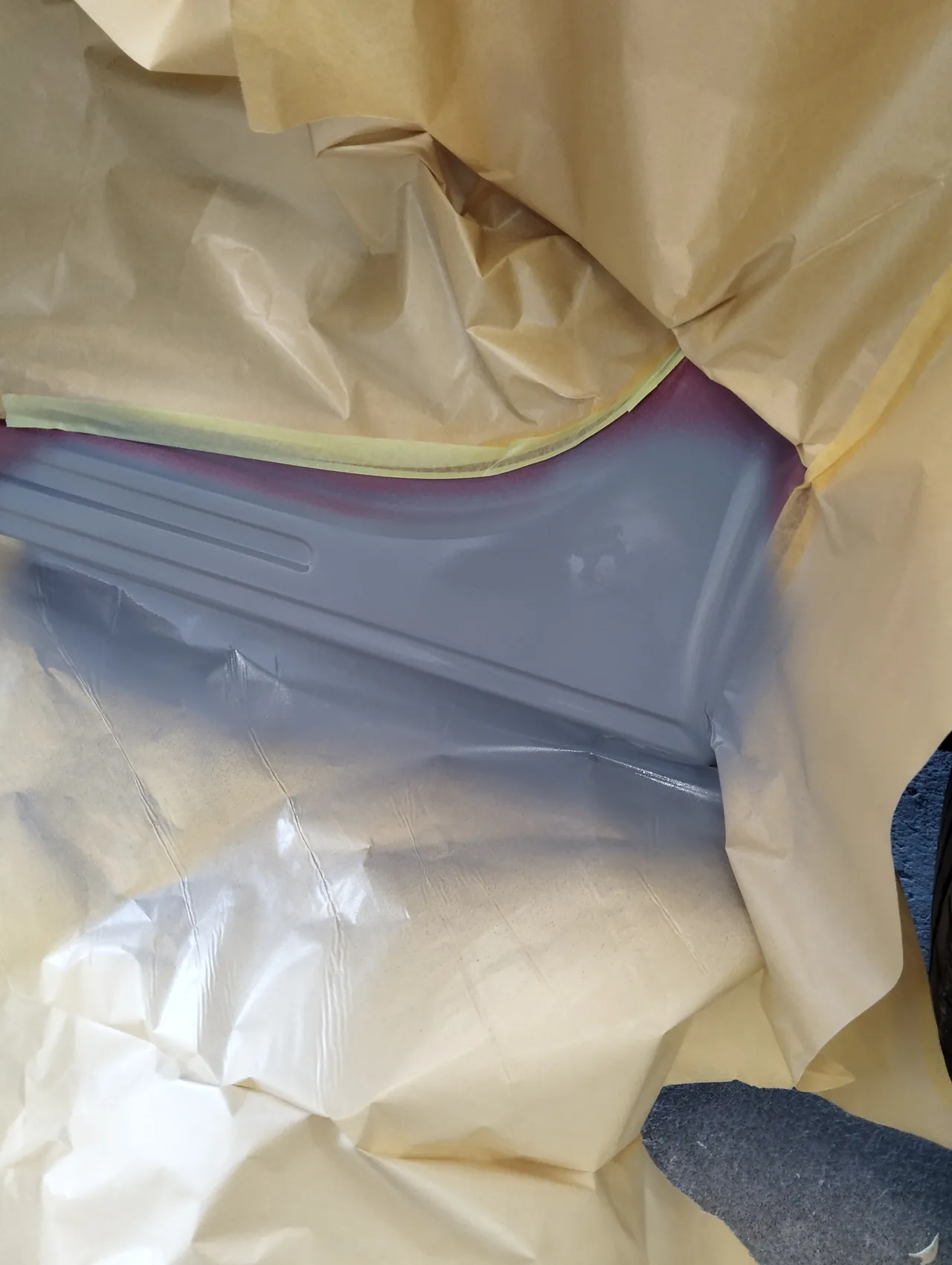 マツダ CX-5のサイドシルの後ろの端に吹いたグレーのサフェーサー（紙で囲った中）