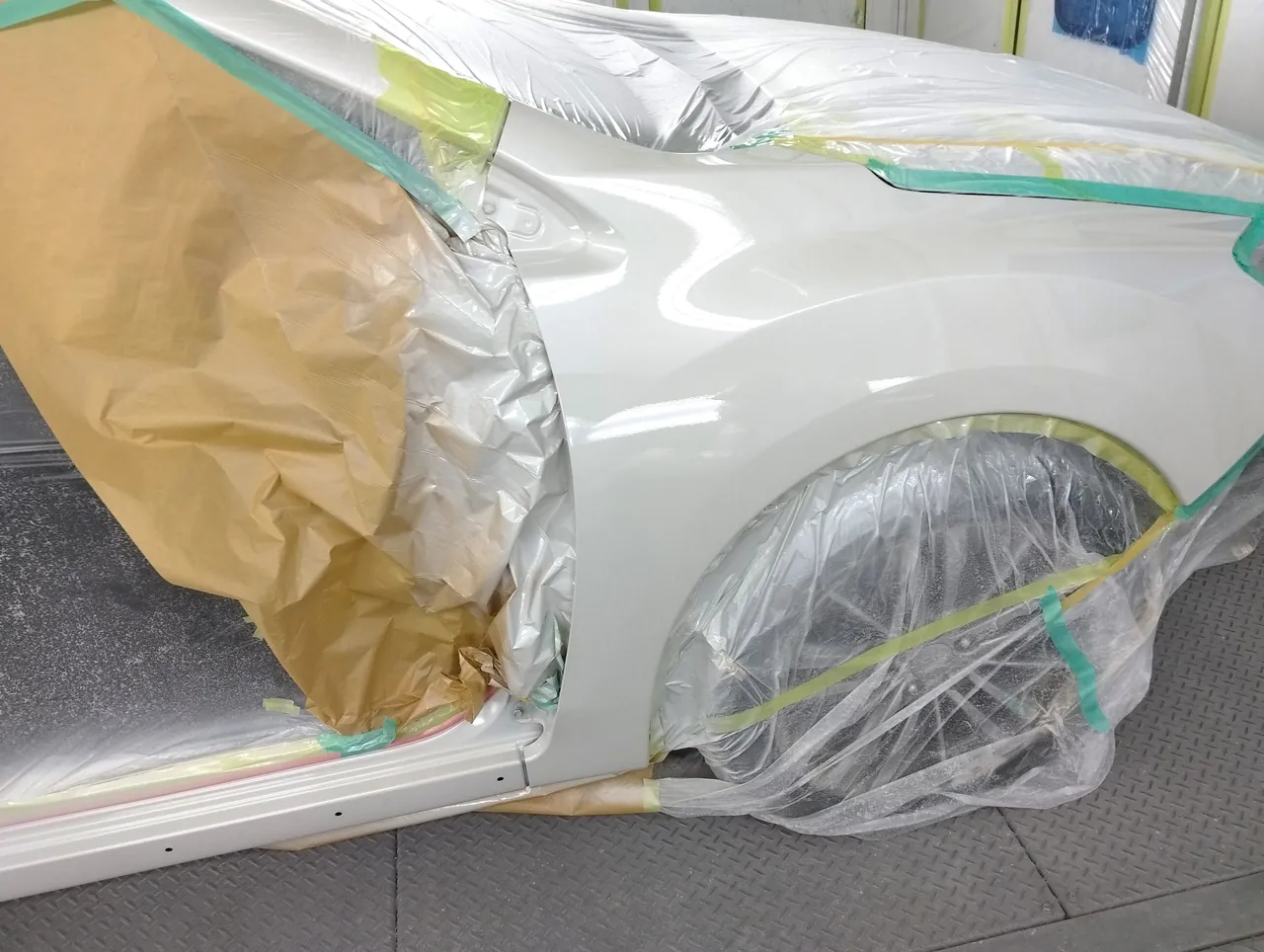 37Jの白に塗り上がったインプレッサの右フロントフェンダー（前ドアの開口部側は紙で覆う）