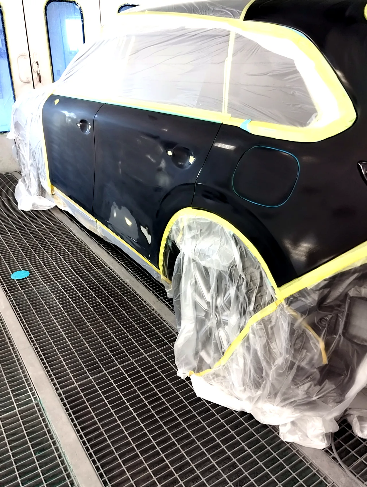 塗装ブースのCX-80の左側面の後ろ側。左リヤドアと、給油口のふたを含む左リヤフェンダーを研いだ状態(塗る前)