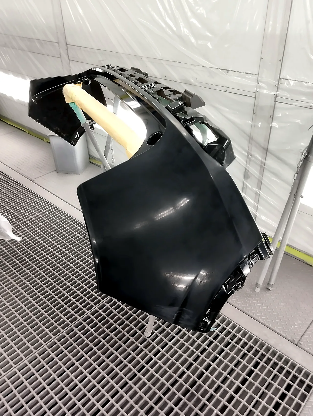 塗装ブースの台に載せた、ヴェゼル e:HEVのリヤバンパー（塗る前）