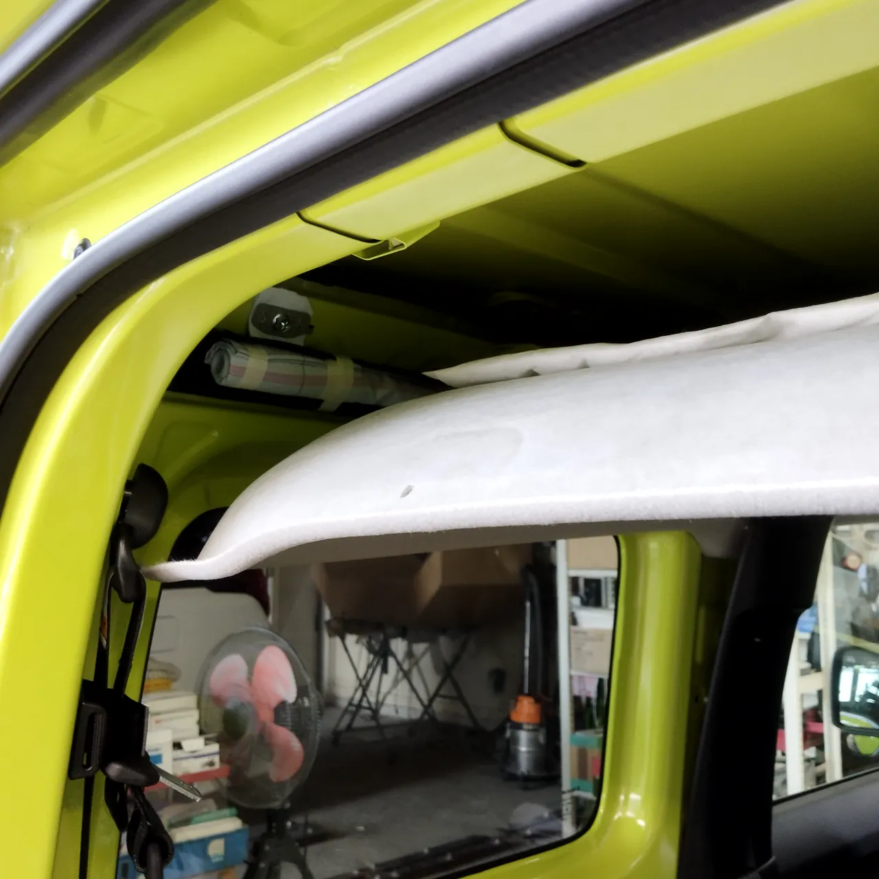 天井の内張りを後ろ側から下ろしたジムニー（JB64）の車内。上に屋根の裏の鉄板が見える