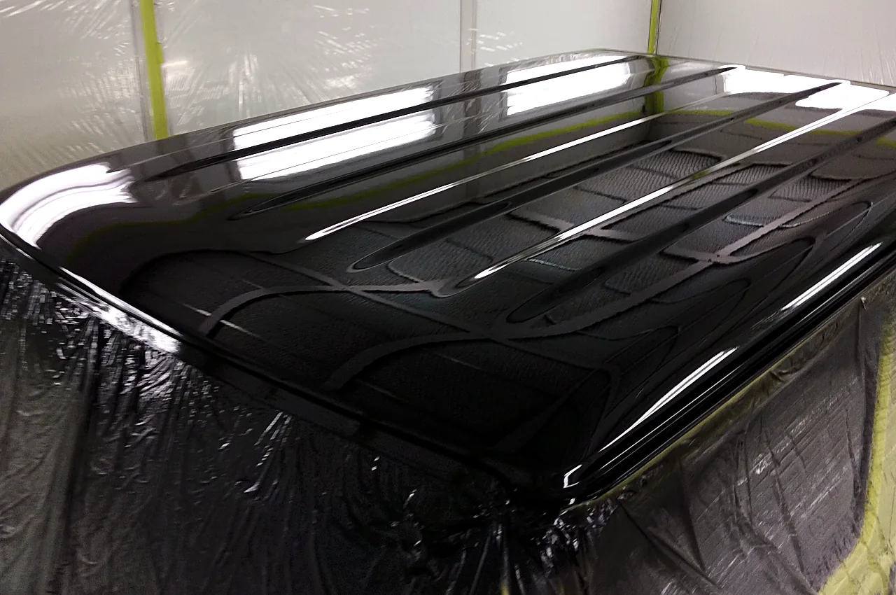 塗装ブースで屋根全体を黒で塗り終えたジムニー（JB64）。天井の照明が映り込む（塗装後）