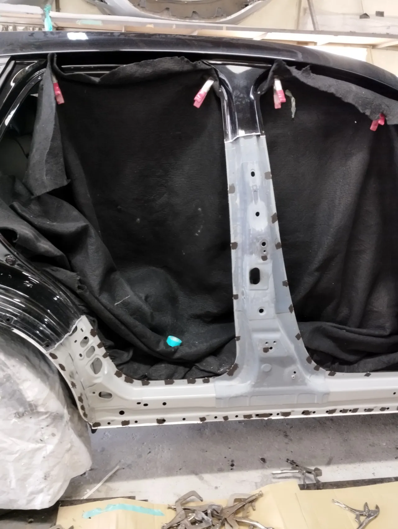 マツダ CX-60のBピラーとサイドシル。外側の鉄板を外し、内側の明るい灰色の板が見える。車内は黒い布で覆う