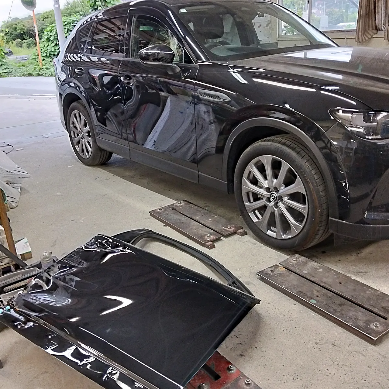 組み上がったマツダ CX-60の右前と、床に置いた外した元の右前ドア(工場の中)