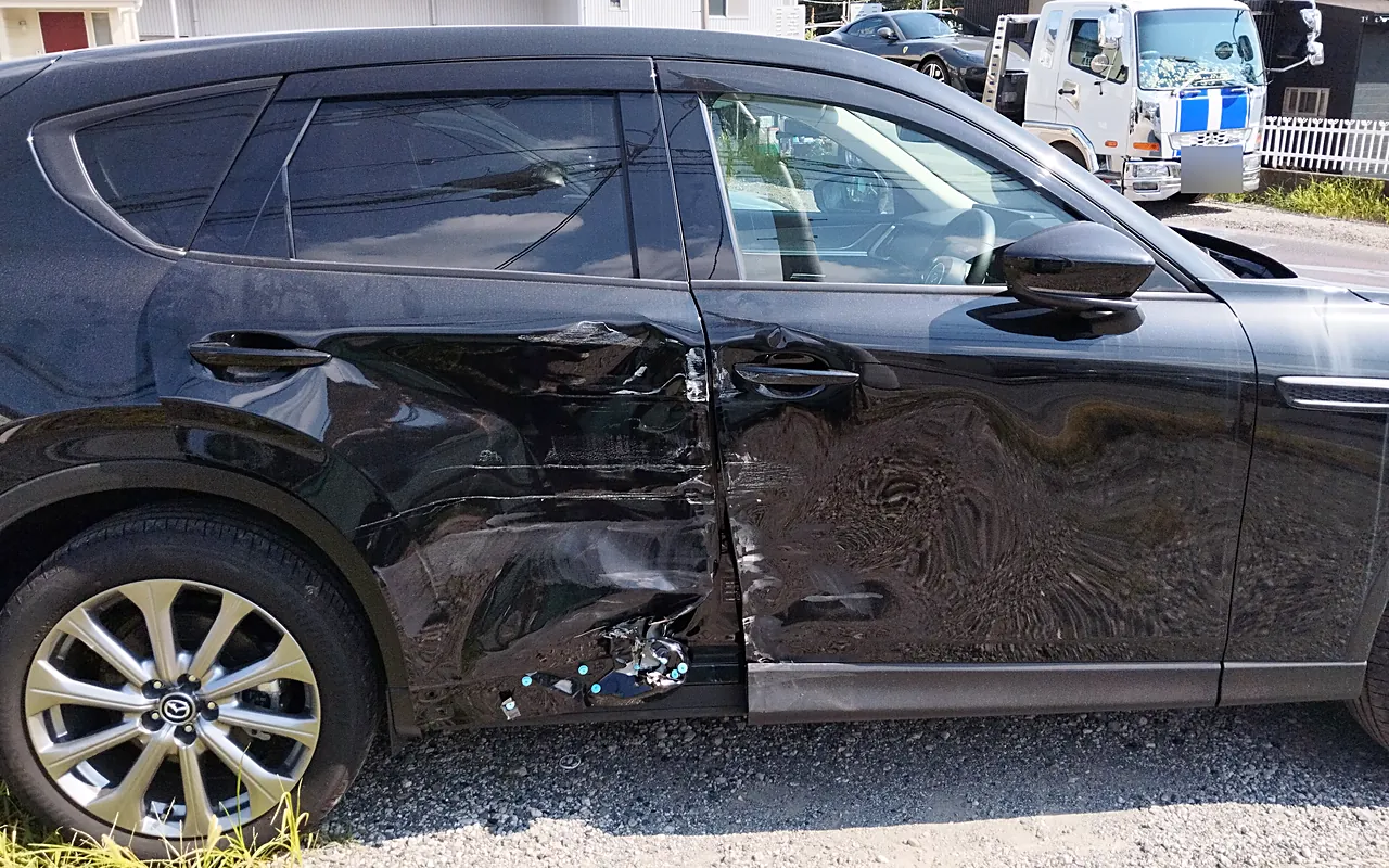修理前のマツダ CX-60の右側面。前後のドアの境目を中心に大きなへこみ、ドアの下のサイドシルもつぶれる(右の真横から)