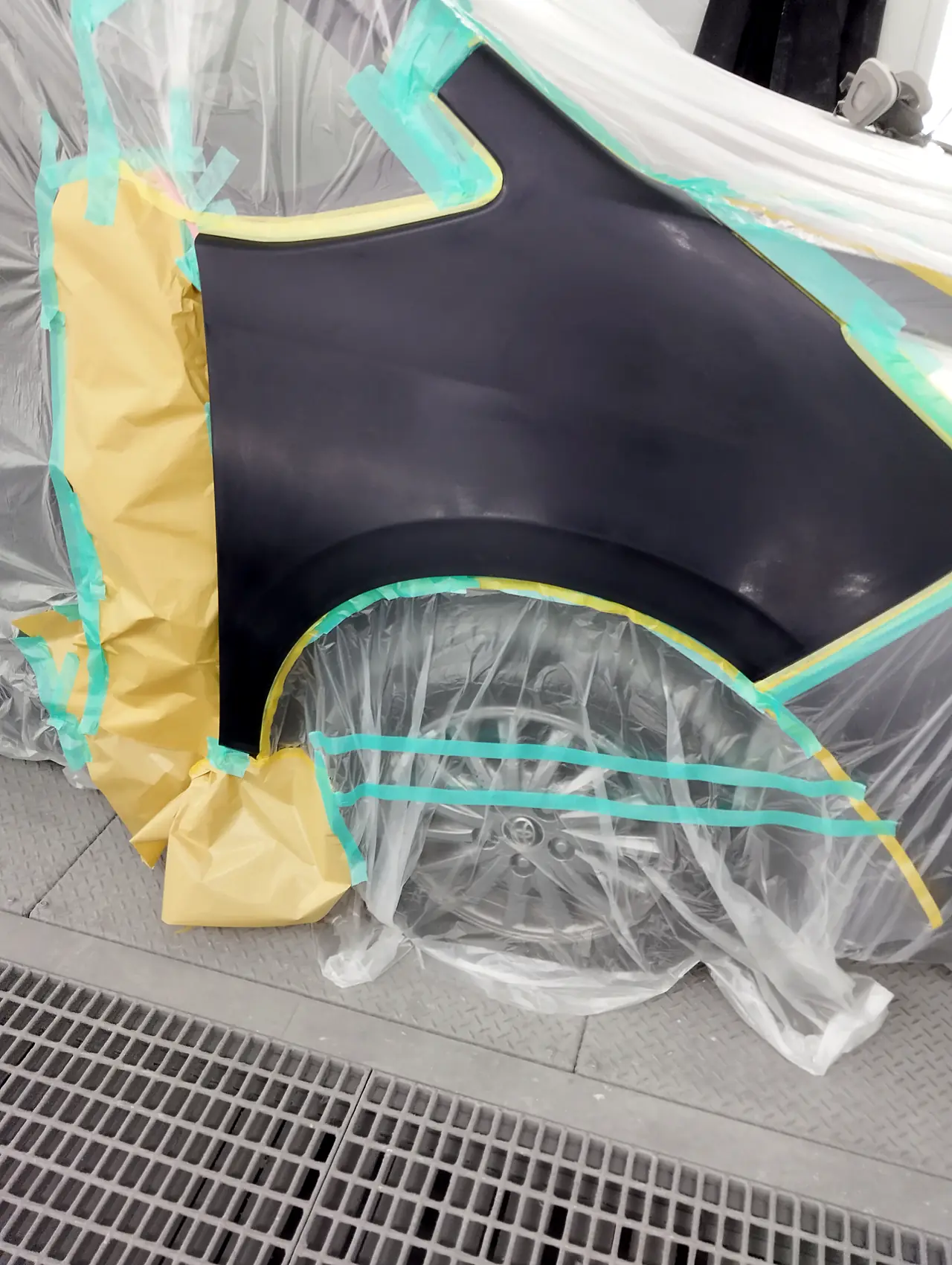塗装ブースのエスクァイア。右リヤクォーターの縁に細い黄色のテープ、タイヤと車体はビニールと紙で覆う（塗っている途中）
