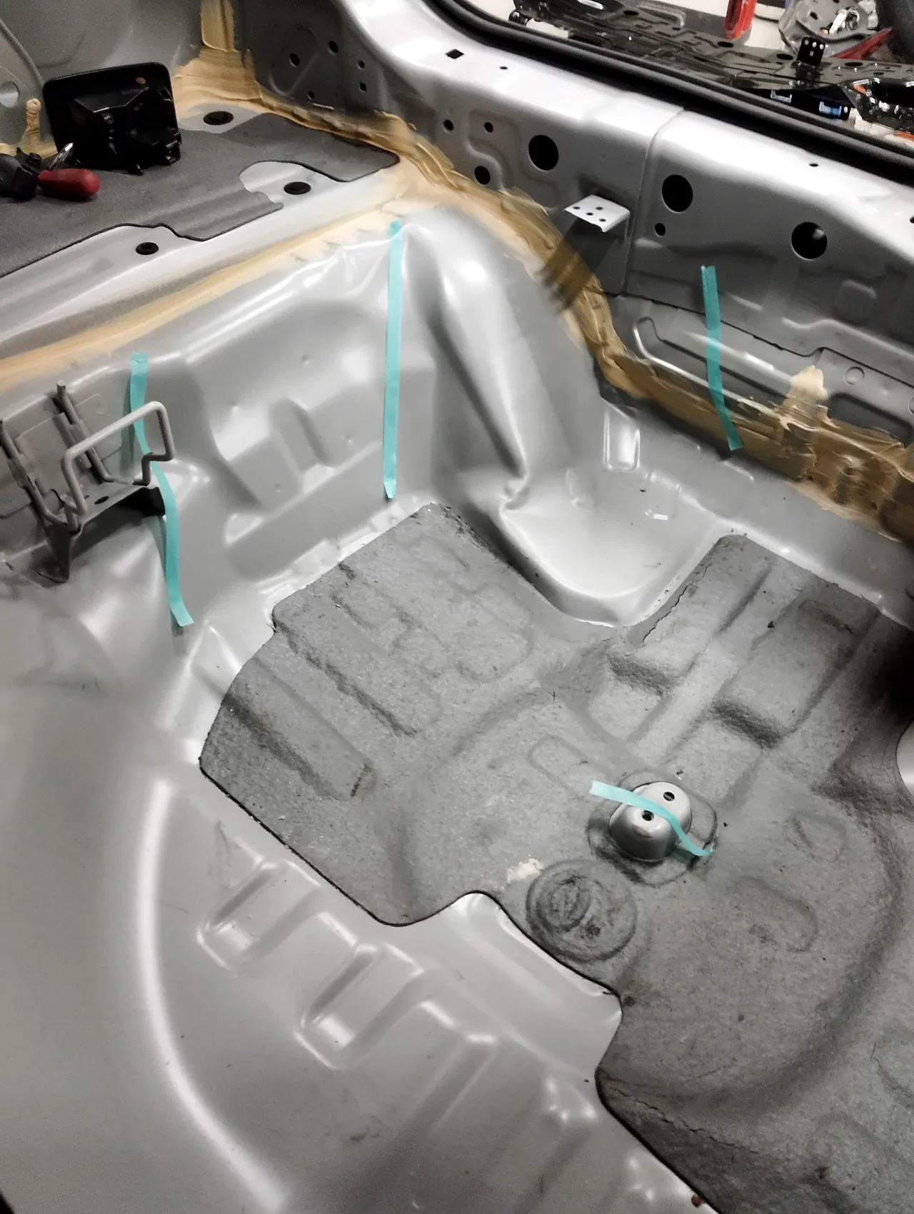 ホンダ CR-V の荷室の床（スペアタイヤの所）。しわに沿って緑のテープの線（修理前）