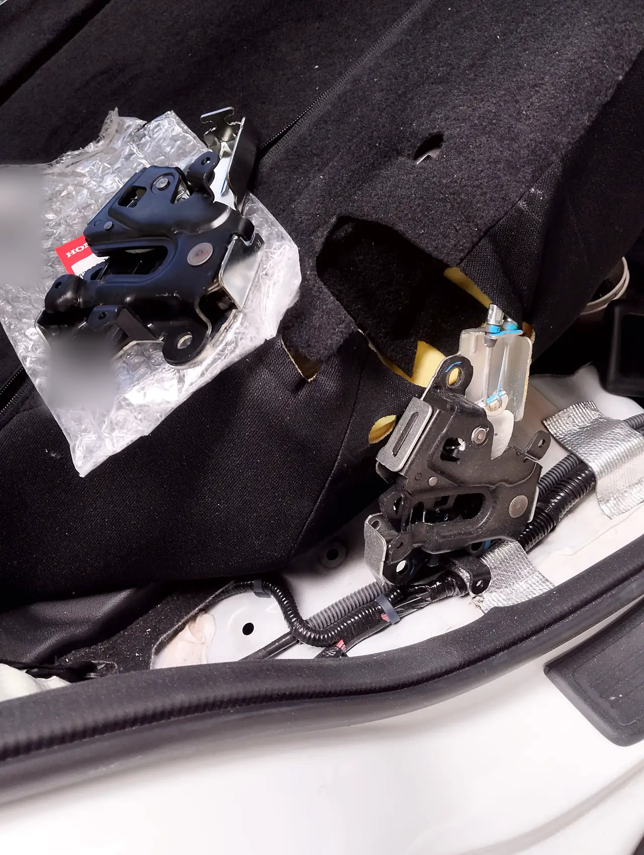 後ろの座席の上に置いた、袋に入ったホンダ CR-V の新しい背もたれのロック