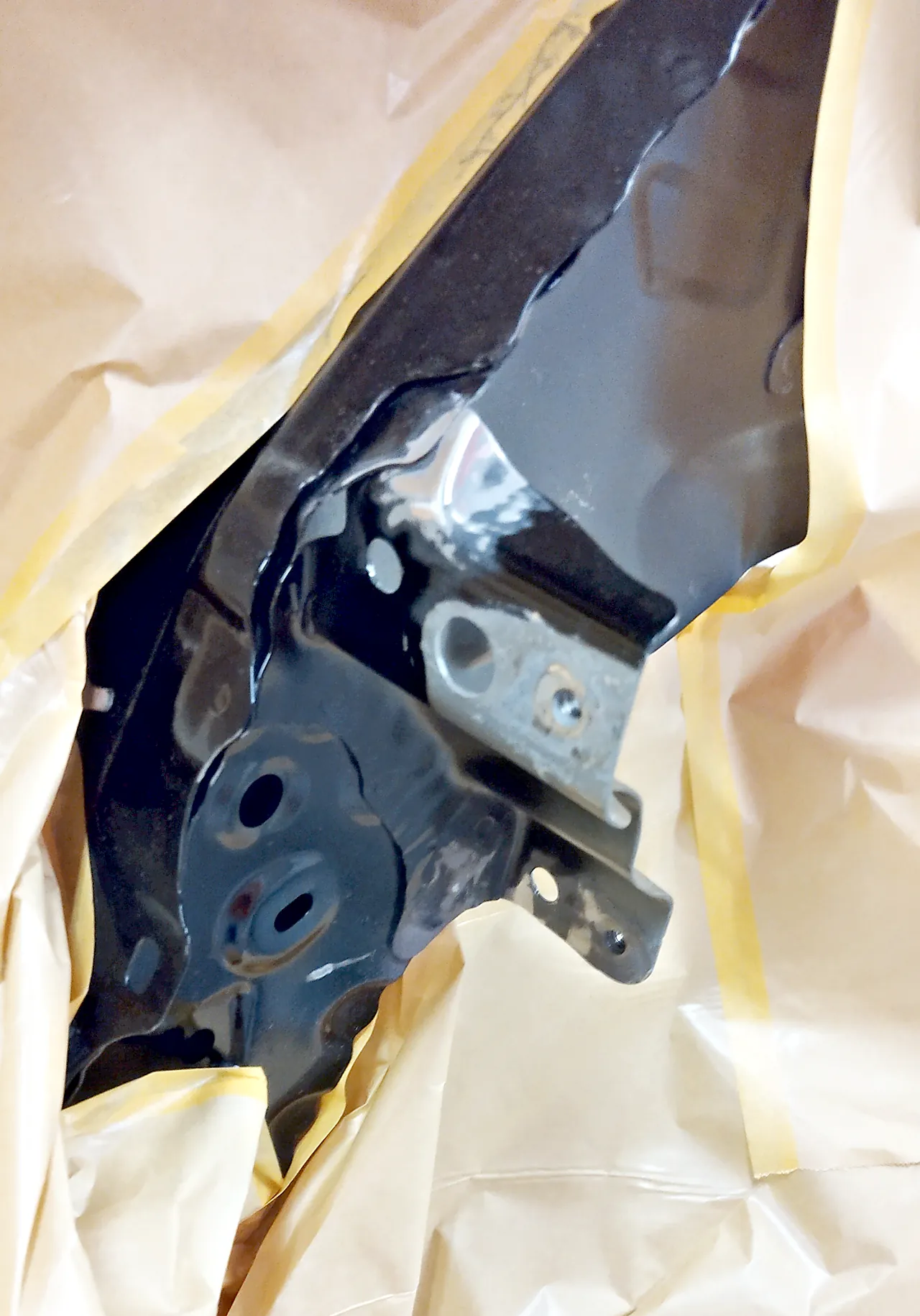 40系アルファードのフェンダーの内側に隠れる車体の一部。まわりを紙でマスキングした塗る前の状態