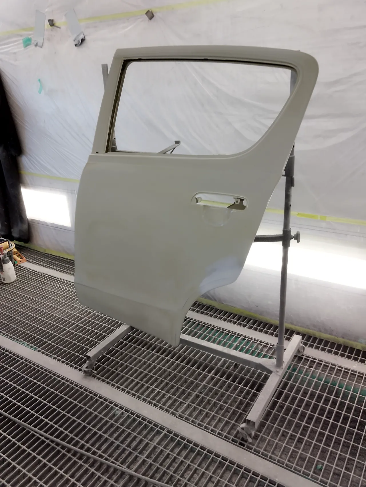 塗装ブースのスタンドに立てた、取り寄せたアルト エコの左リヤドア(まだ車の色が塗られていない状態・ガラスなし)