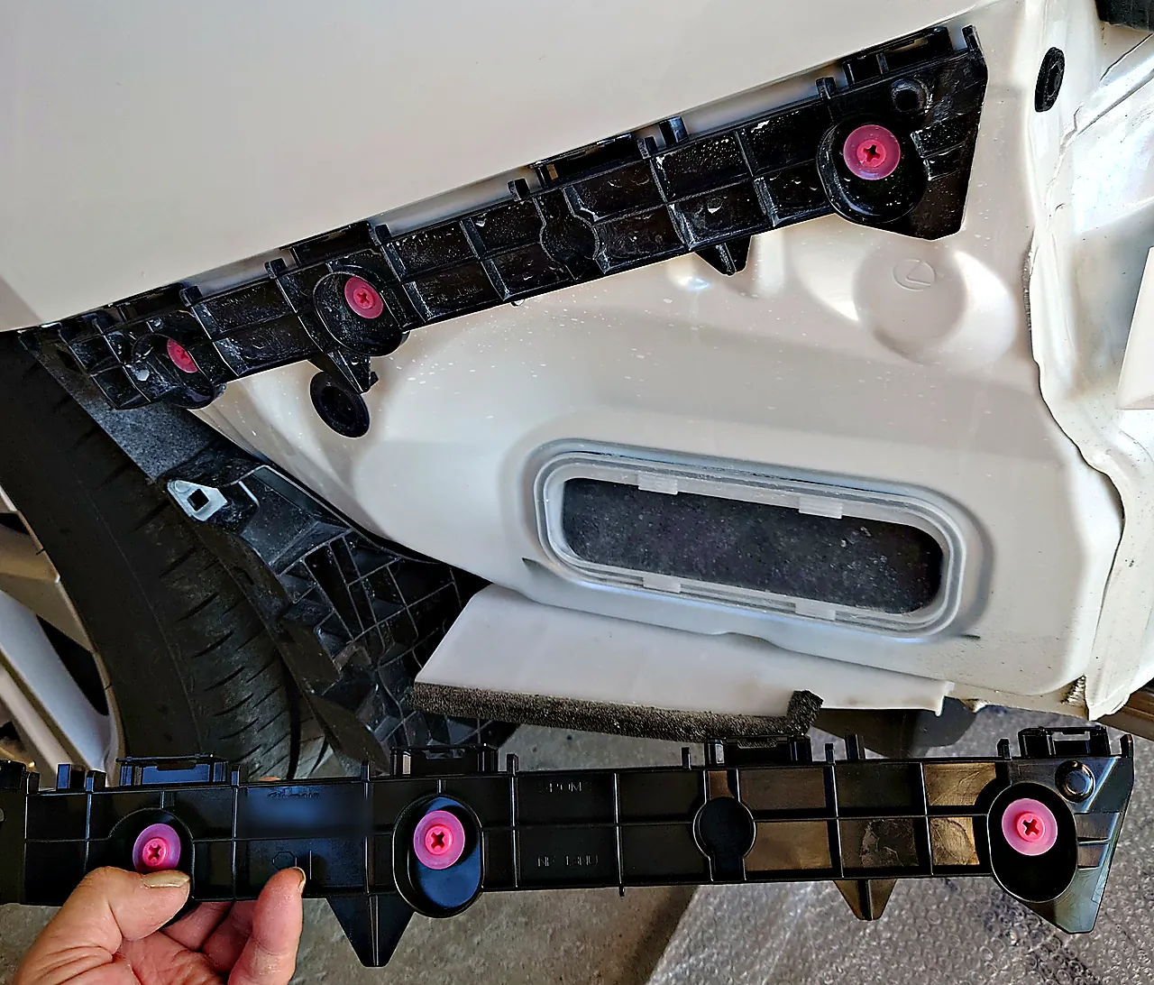 レクサスIS 300hの車体に付いた元のリヤバンパーサポート(左)と、その下で手に持った取り寄せたサポート