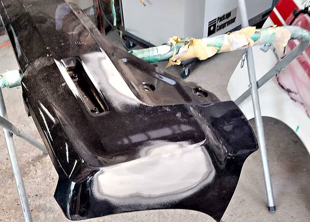 スタンドに載せたスペーシア カスタムのリヤバンパー。右の角を段をつけて研いだ跡