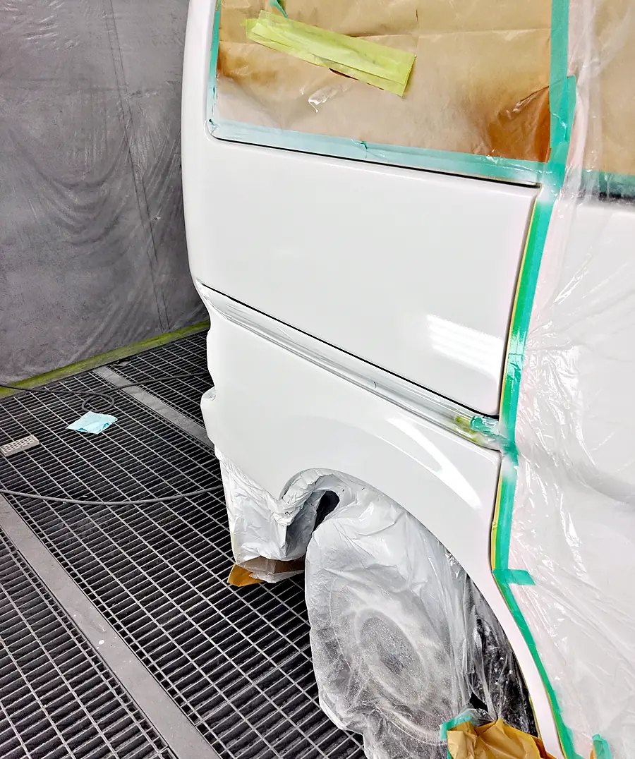 カラー番号QM1の白で塗り終えたNV200バネット バンの右リヤクォーター（塗装後）
