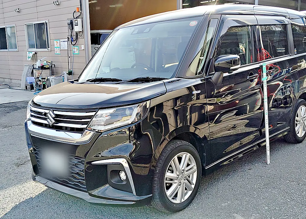 修理の前のスズキ ソリオを左前から。スライドドアの横に目盛りの付いた棒