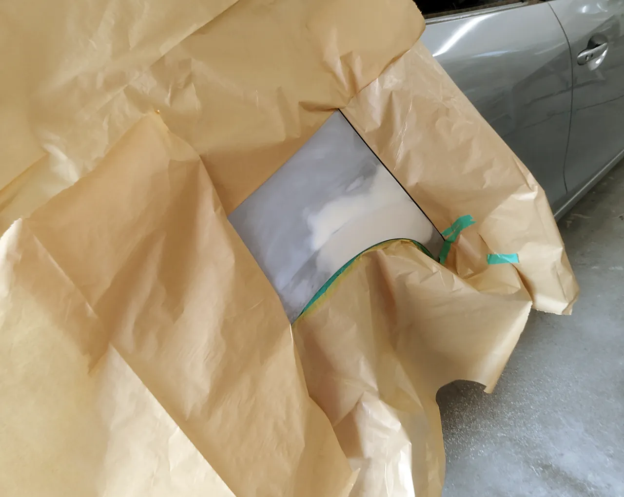 アクセラの右リヤクォーター。研いだ所とパテのまわりだけを出し、紙で大きく覆ったところ（サフェーサーの前）
