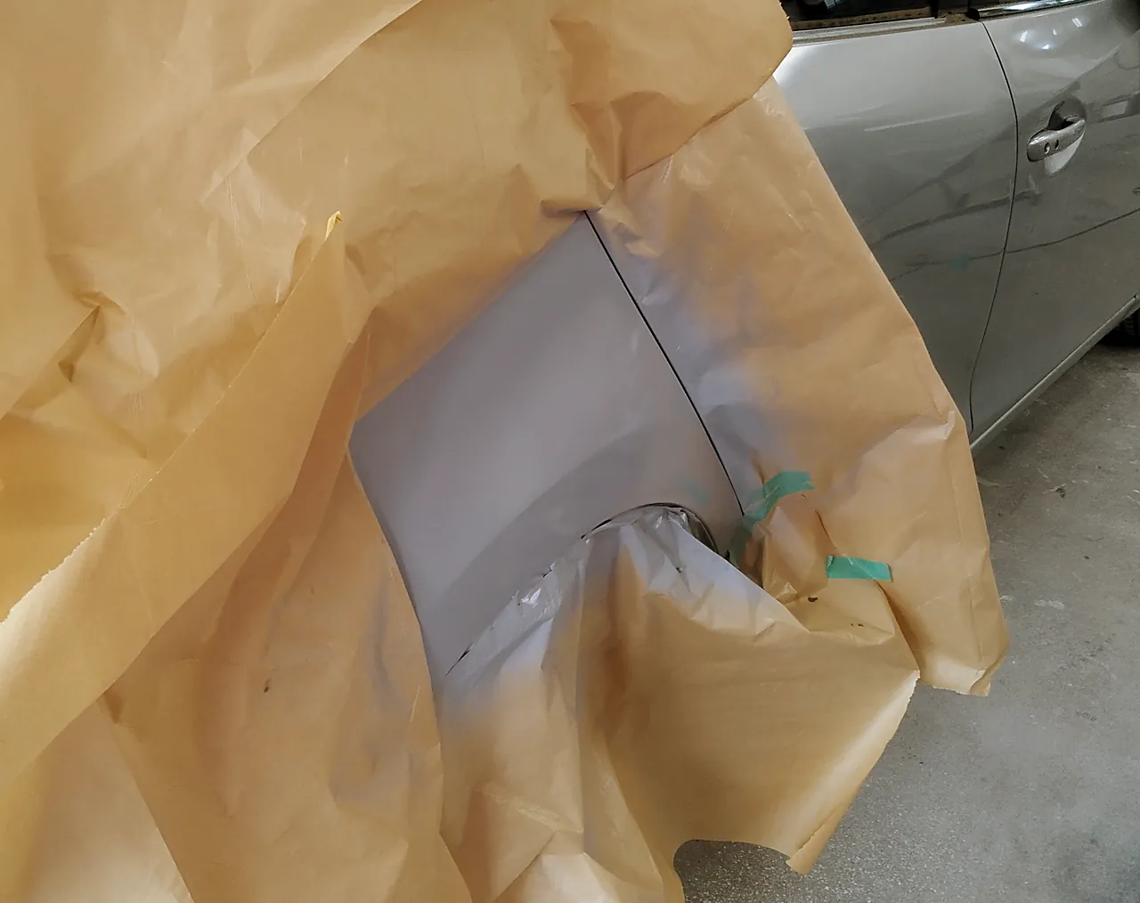 アクセラの右リヤクォーター。紙で覆った中に吹いたグレーのサフェーサー