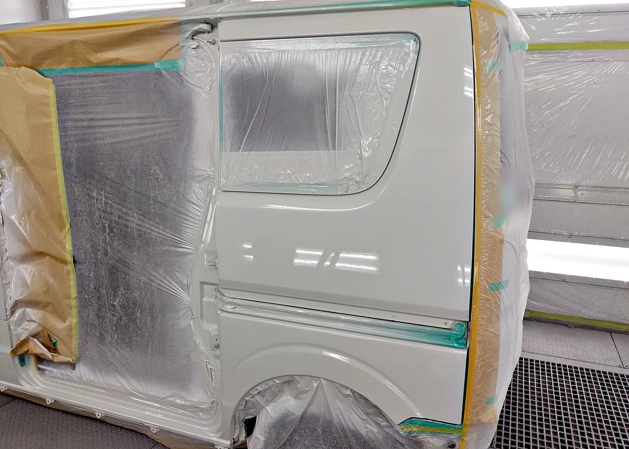 カラー番号Z7Tの白に塗り終えたエブリイワゴンの左リヤクォーター。窓の下から後輪のまわりまでつやが出ている（塗装後）