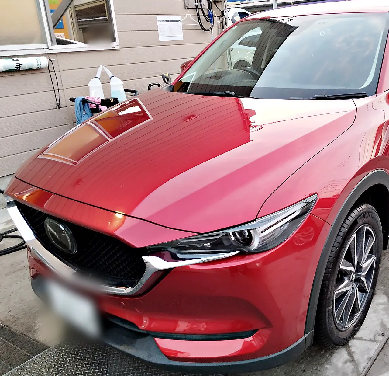 修理を終えたマツダ CX-5を左前の斜めから。塗り直した左フロントフェンダー（外で撮影）