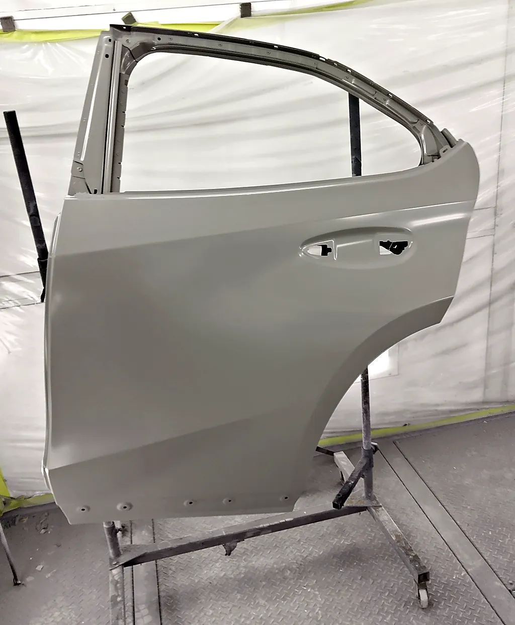 レクサスUX250hの取り寄せた新しい左リヤドア。台に立てた塗る前の状態で、まだ車の色が付いていない（塗装ブース）